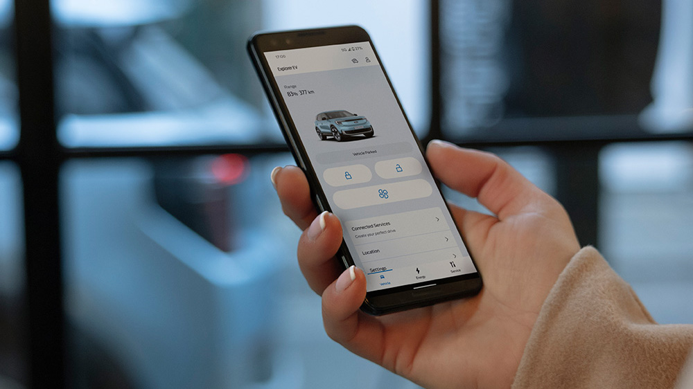 A ckise up of a hand holding a smartphone and interacting with the FordPass app.