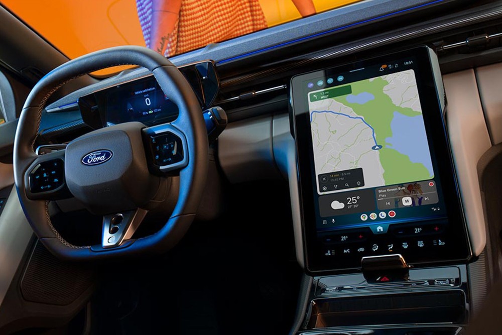 The interior of the all-electric Ford Capri showing the steering wheel and SYNC Move touchscreen.