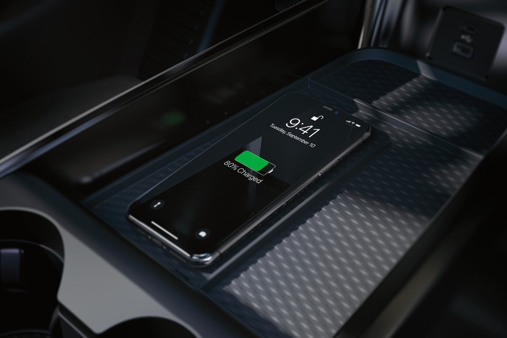 A close up of the wireless charging pad in the centre console, showing an iPhone being charged.