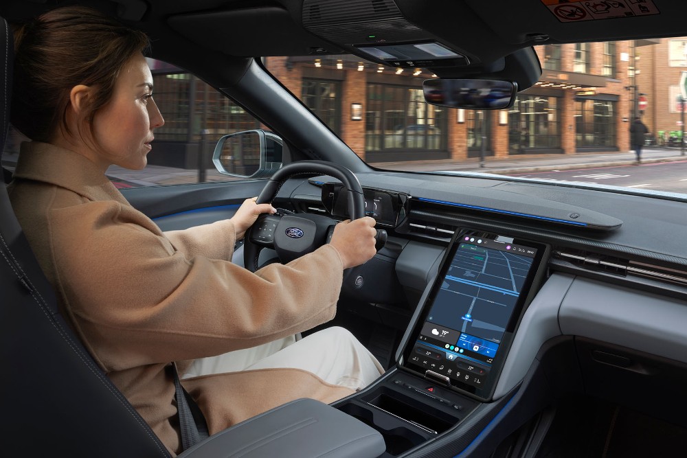 An interior photo of a woman driving the Ford Explorer along a city road.