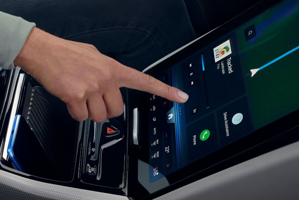 A woman interacting with the large SYNC touchscreen in the Ford Explorer.