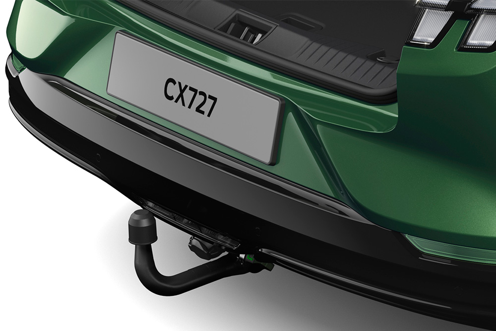 A close up of the electric tow bar on a green Ford Mustang Mach-E, photographed in a studio on a white background.
