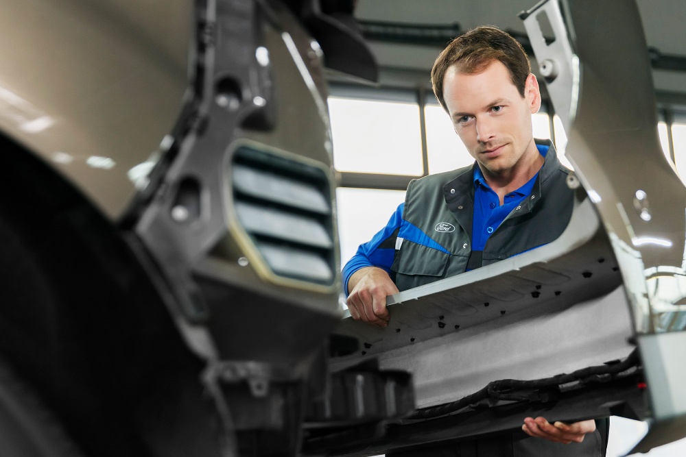  Ford technician replacing a front bumper