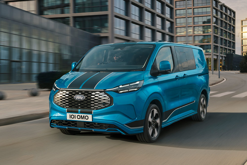 Blue Ford E-Transit Custom Sport Double Cab-in Van driving on a city street.