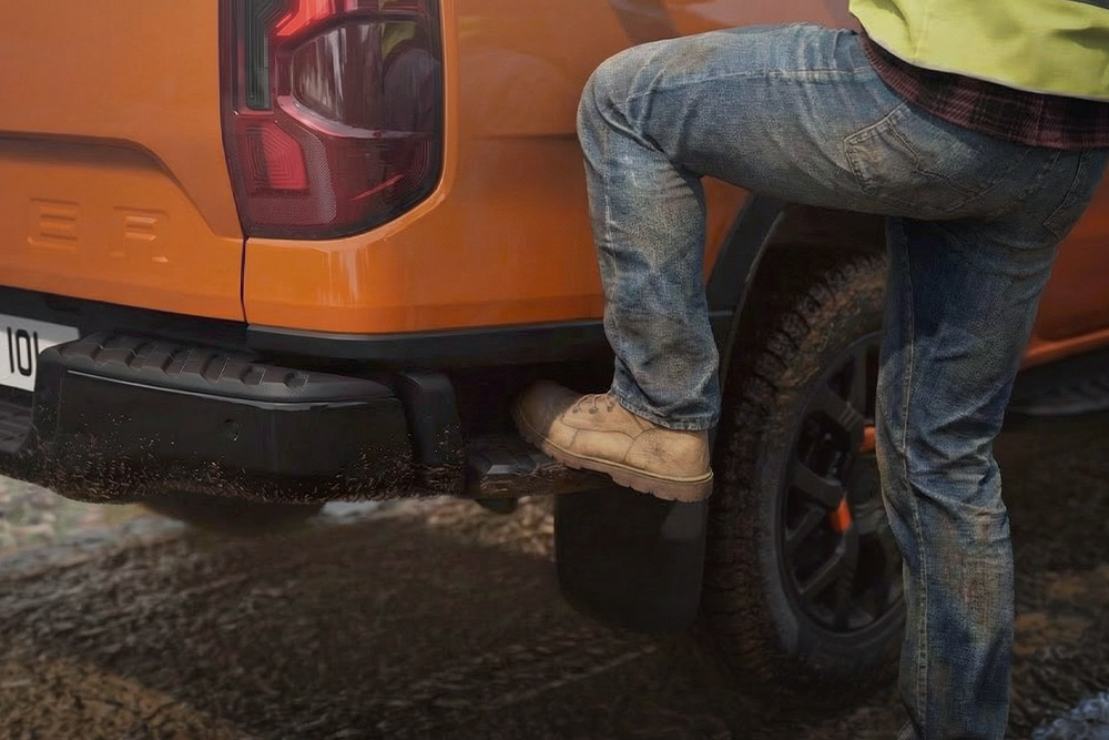 Worker stepping onto the integrated rear step of the Ford Ranger Wildtrak.
