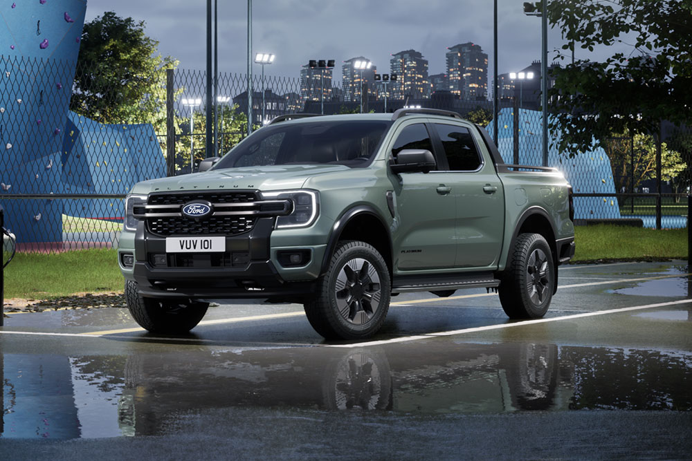 Grey Ford Ranger PHEV parked in front of an urban cityscape at dusk.