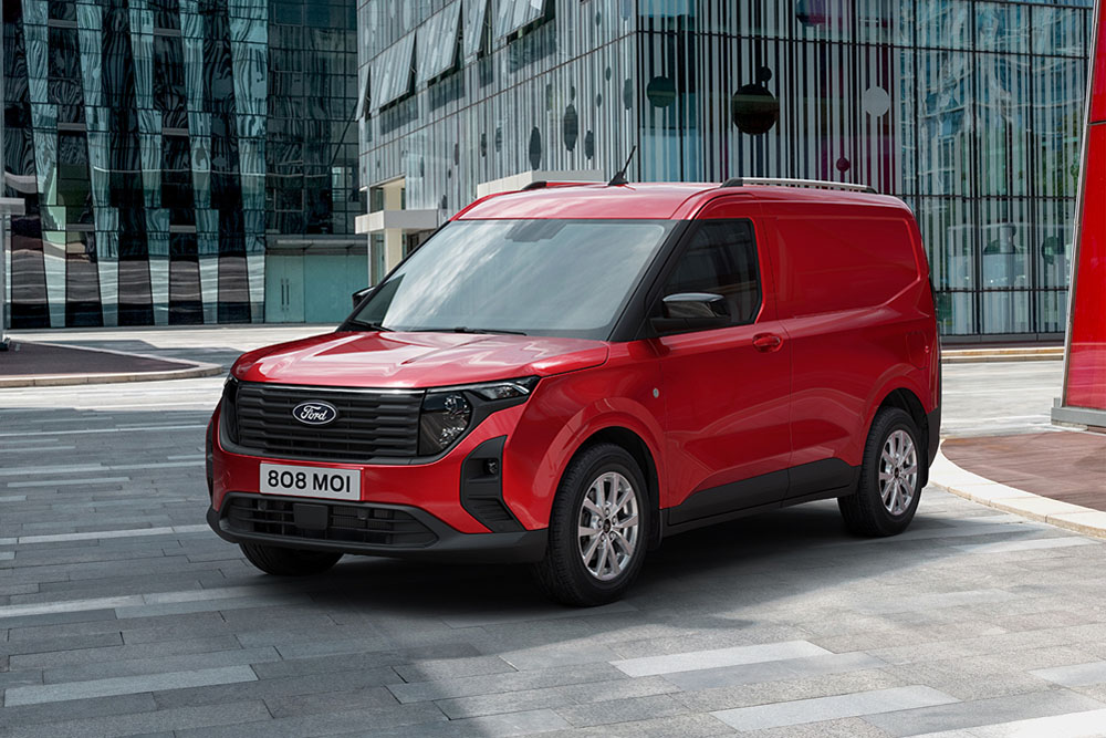 New red Ford Transit Courier Van parked near modern building