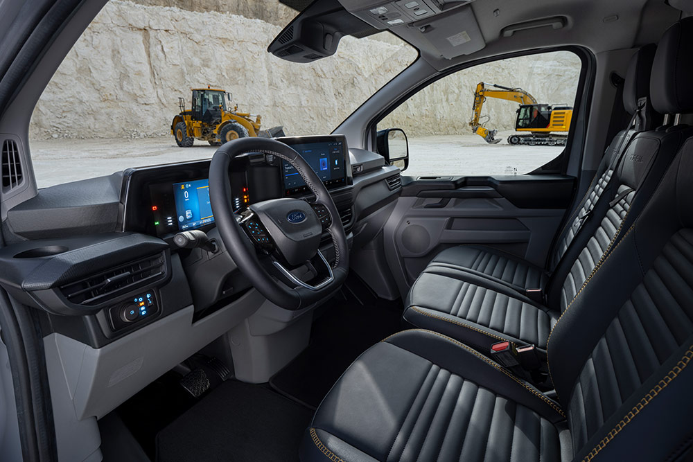  Interior view of a Ford Transit Custom van, showing the dashboard, steering wheel, and seats.