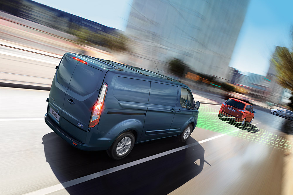 Rear view of a blue Ford Transit Custom, with green lines indicating driver assistance features.