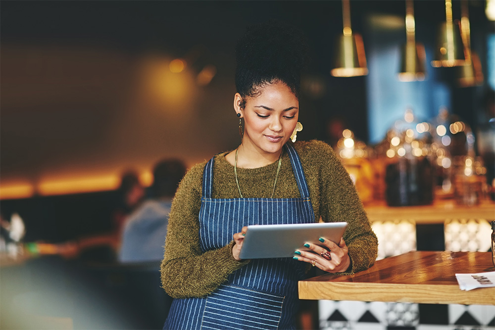 A restaurant owner checking her company car tax on a tablet computer.