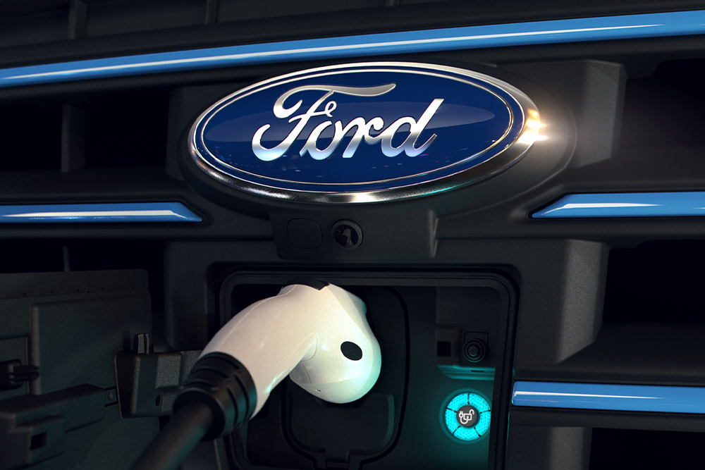 Close-up of a white charging cable plugged into the front charging port of a Ford electric vehicle.