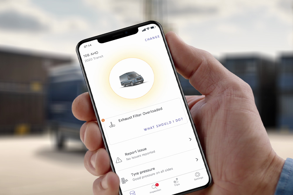 A hand holding a mobile device, showing the Ford Telematics Drive app.